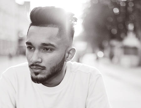 Stylish indian beard man at pink t-shirt. India model posed outdoor at streets of city sunset.